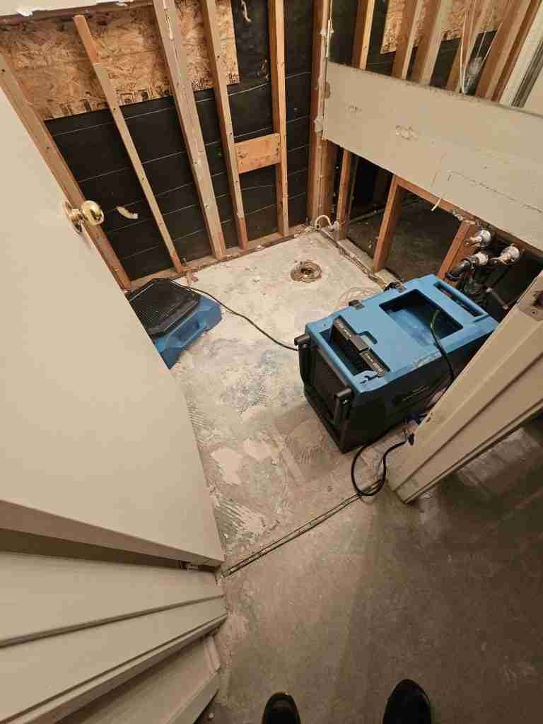 Water Damage Restoration 23 Exposed wall and cabinet area with professional drying equipment operating during water mitigation